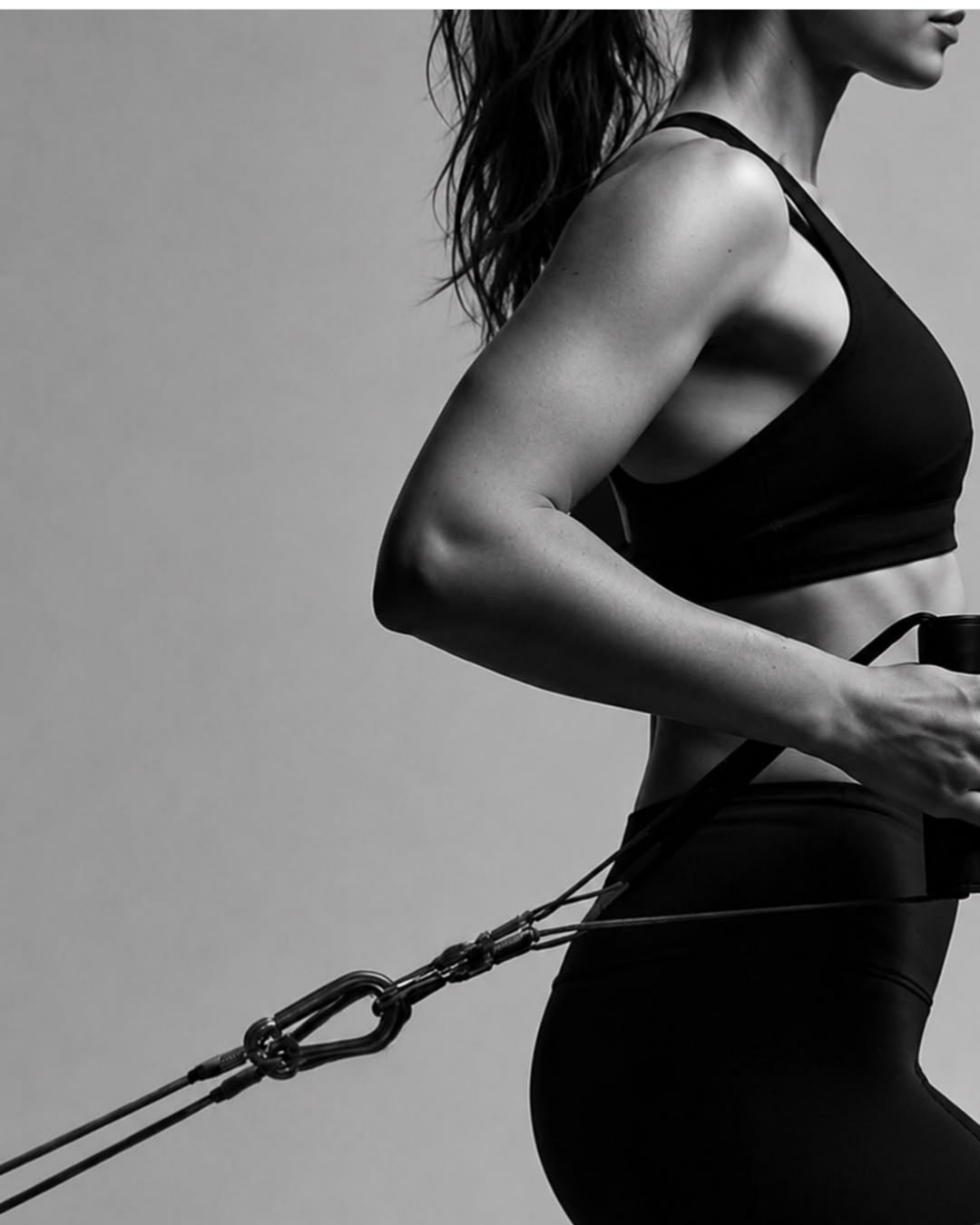 Black and white photo of a client pulling the Lagree machine cables